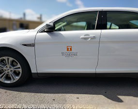 Side view of a car with the UT logo on the front door